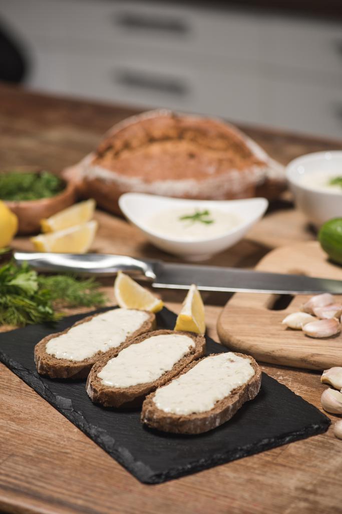 Ψωμί με σάλτσα τζατζίκι με φρέσκα υλικά σε ξύλινο τραπέζι  - Φωτογραφία, εικόνα