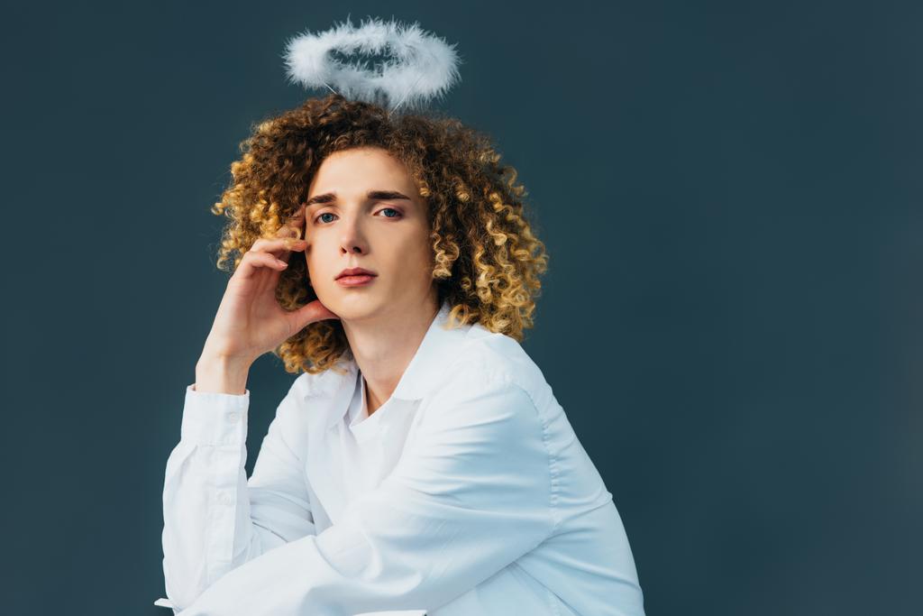 dreamy curly teenager in angel costume with halo above head isolated on green - Photo, Image