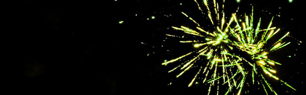 panoramisch schot van groen feestelijk vuurwerk op feest, geïsoleerd op zwart - Foto, afbeelding