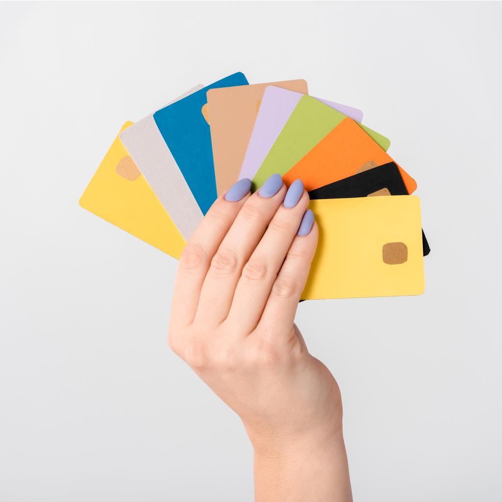 обрізаний вид жінки, що тримає барвисті шаблони кредитних карток в руці ізольовані на білому
  - Фото, зображення
