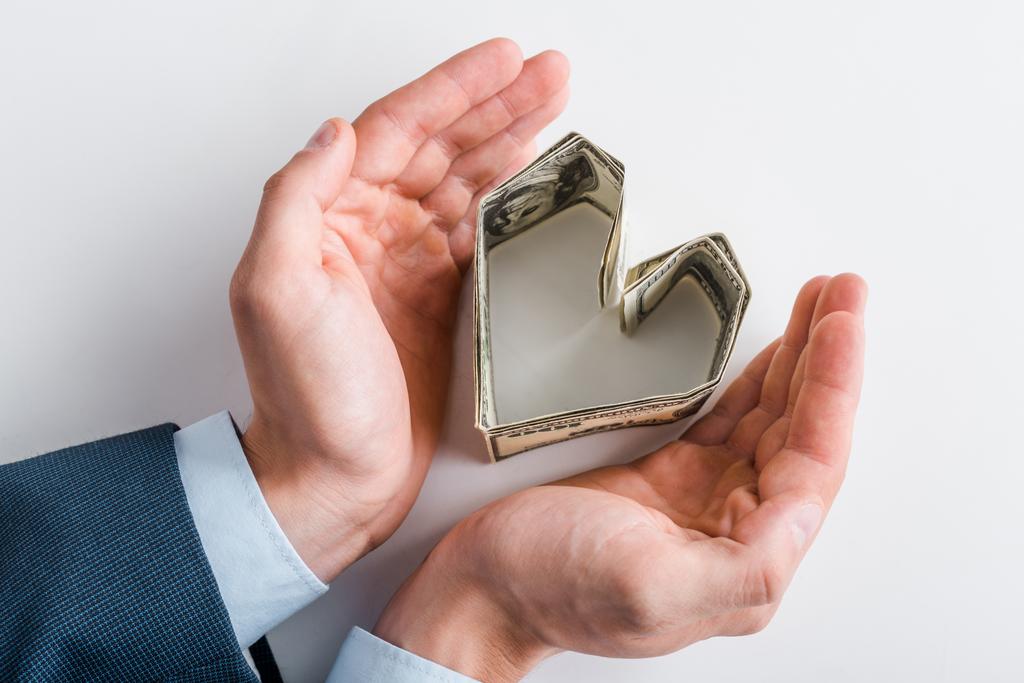 Top näkymä liikemies lähellä sydämen muotoinen dollari seteleitä valkoinen
  - Valokuva, kuva