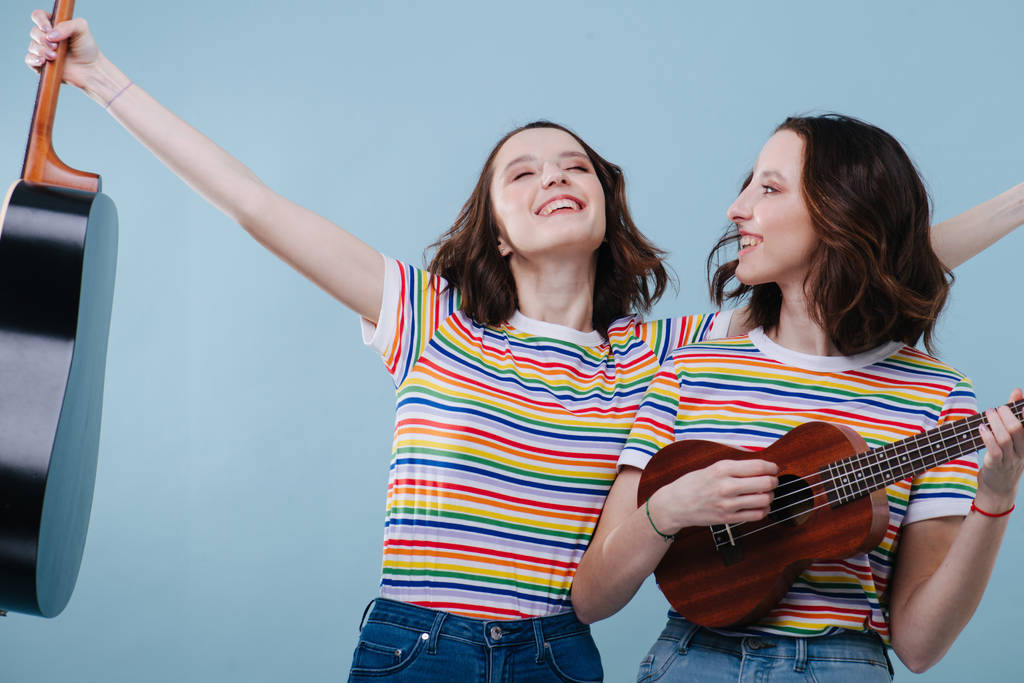 Két feminista örömteli ikerlány gitározik és ukulelézik. - Fotó, kép
