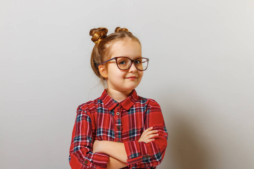 Porträt eines lustigen kleinen Vorschulkindes mit Brille auf grauem Hintergrund. Bildung. Zurück zur Schule - Foto, Bild