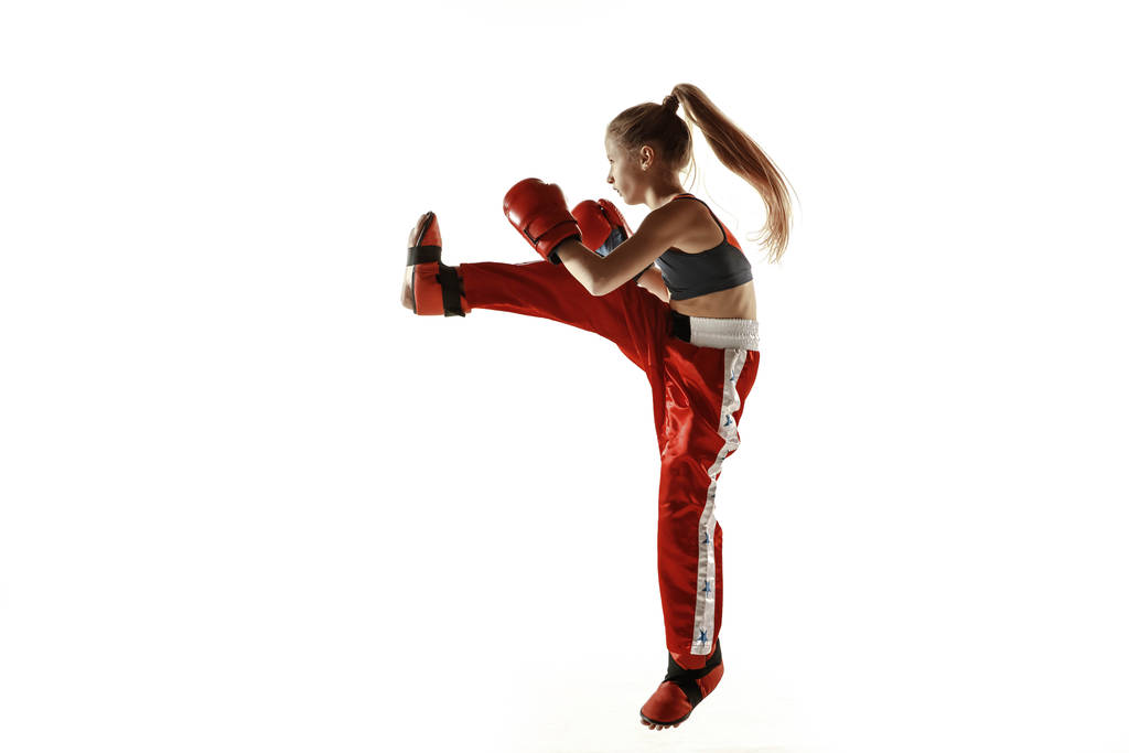 junge Kickbox-Kämpferin trainiert isoliert auf weißem Hintergrund - Foto, Bild