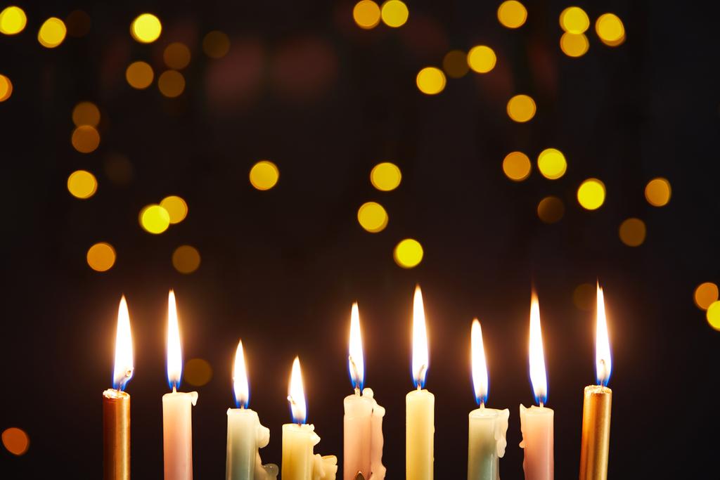 velas brillantes sobre fondo negro con luces bokeh en Hanukkah
 - Foto, Imagen