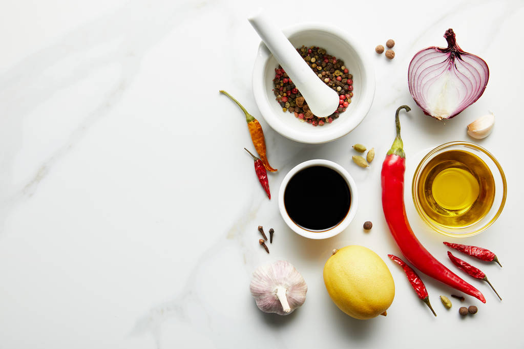 Άποψη μπαχαρικών με ελαιόλαδο και σάλτσα σόγιας σε μαρμάρινο φόντο - Φωτογραφία, εικόνα