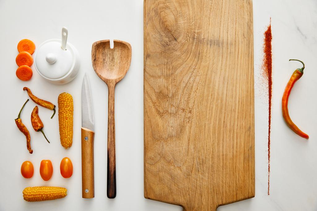 Vista dall'alto di utensili da cucina con verdure e peperoncino spezia su sfondo di marmo
 - Foto, immagini