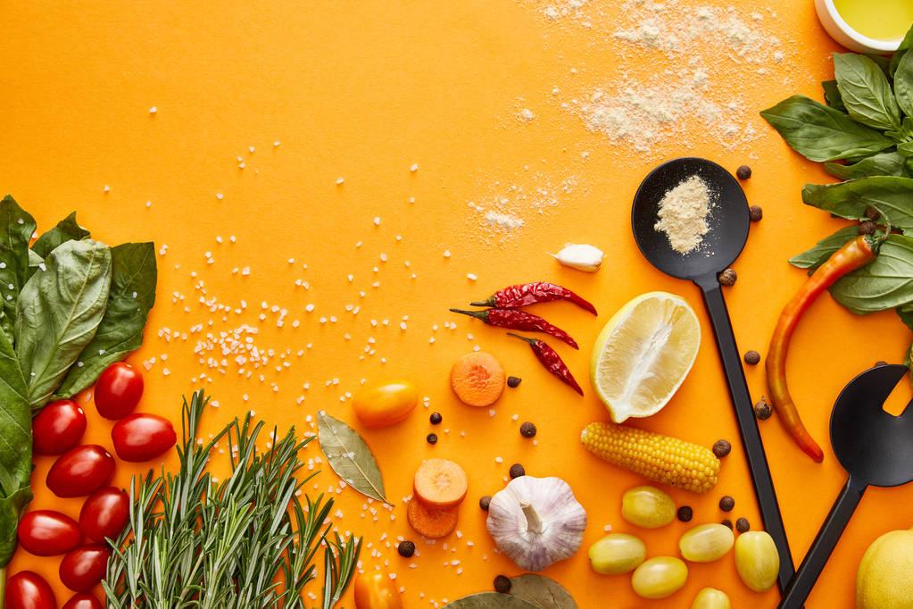 Top view of fresh vegetables, herbs with spices on orange background - Photo, Image