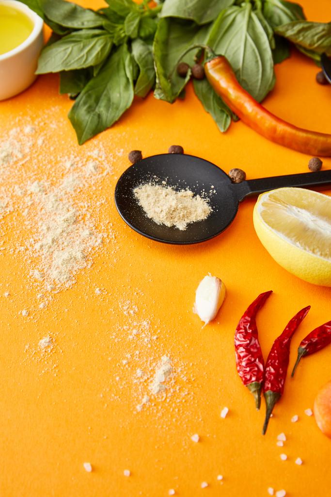 Gewürze, Chilischoten mit frischen Kräutern und Olivenöl auf orangefarbenem Hintergrund - Foto, Bild