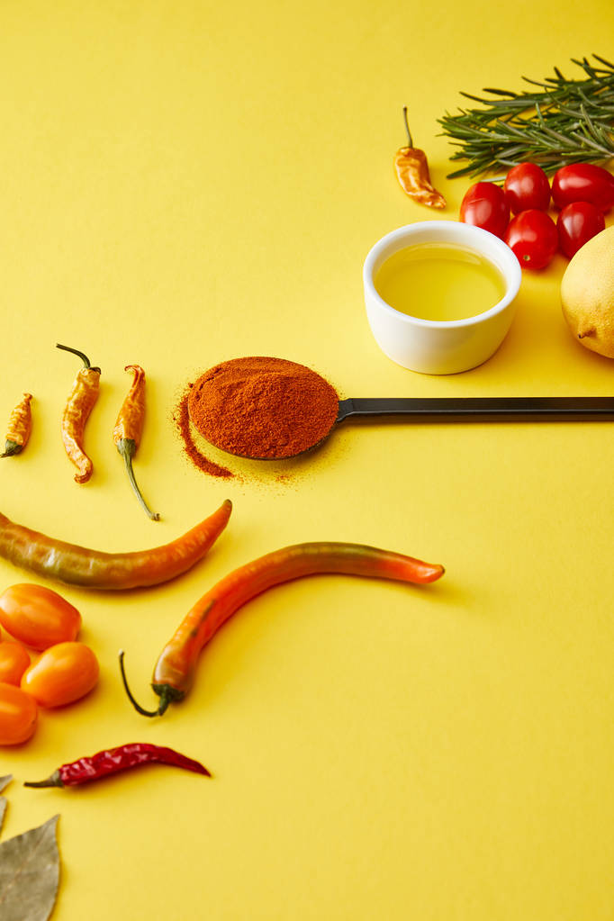 Chili paprika 's met groenten en olijfolie op gele achtergrond - Foto, afbeelding