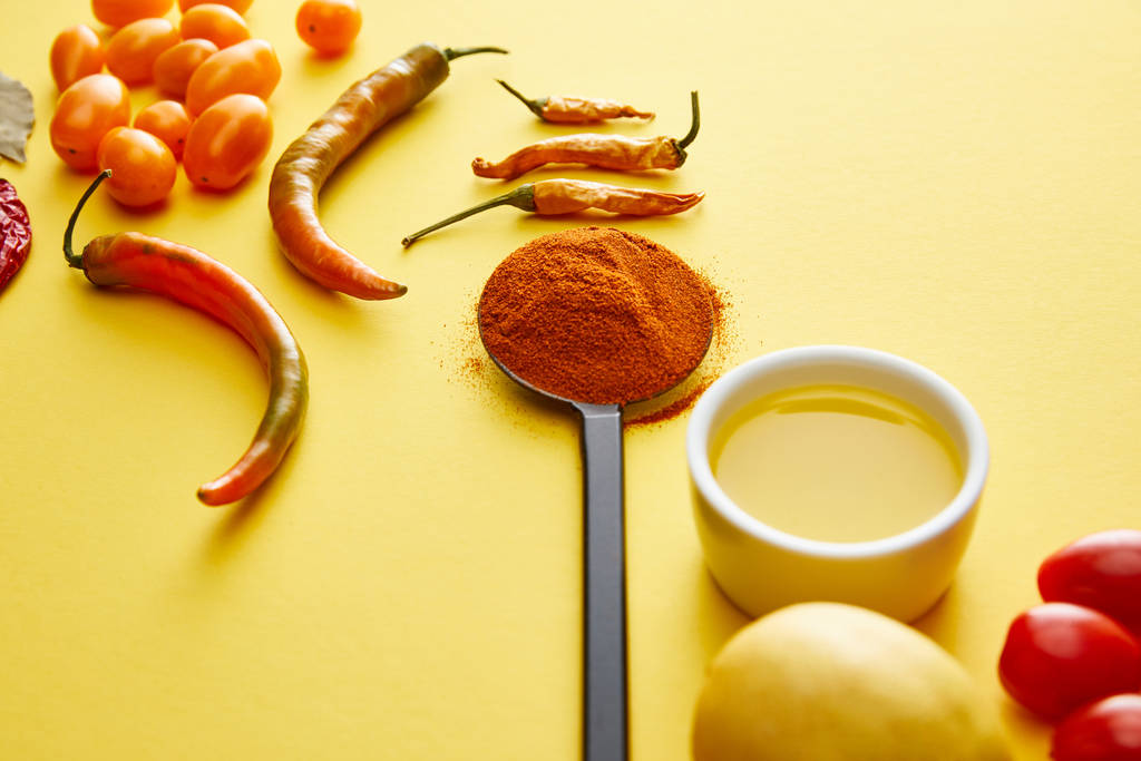 Chili paprika 's met specerijen en olijfolie op gele achtergrond - Foto, afbeelding