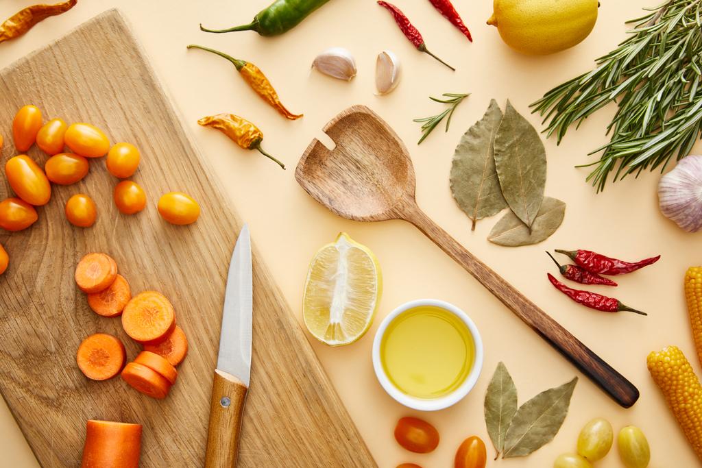 Top view of fresh vegetables on cutting board and spices on beige background - Photo, Image