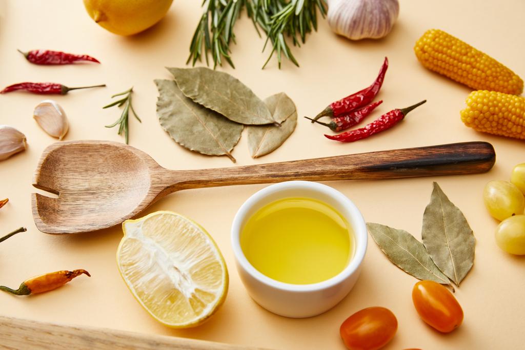 Aceite de oliva con verduras ecológicas y romero sobre fondo beige
 - Foto, Imagen