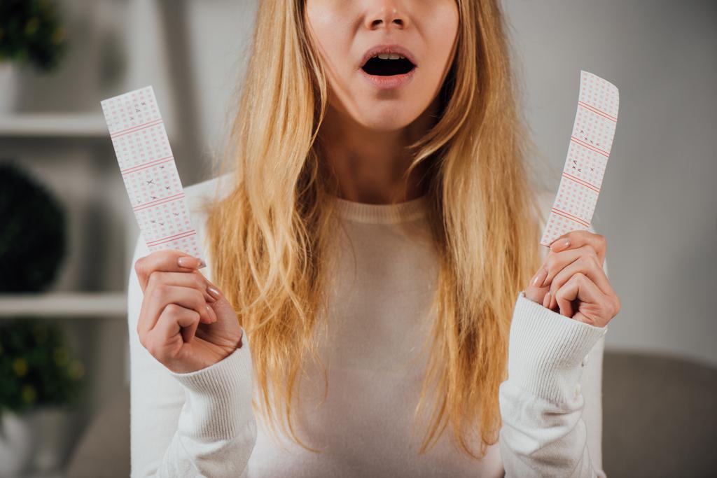 vista ritagliata di donna sorpresa in possesso di biglietti della lotteria
 - Foto, immagini