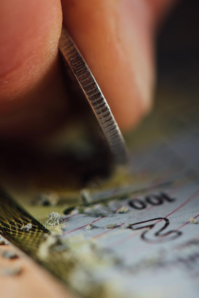Nahaufnahme der Silbermünze in der Hand des Spielers, der Lotteriekarte zerkratzt - Foto, Bild