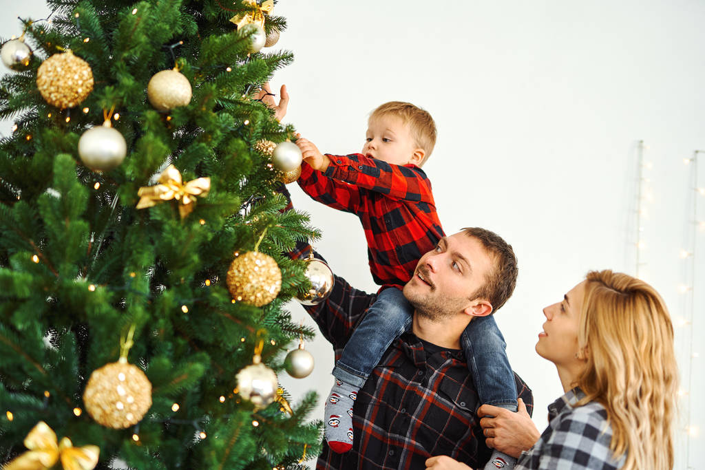 Mladá rodina zdobení vánoční stromeček v předvečer dovolené. - Fotografie, Obrázek