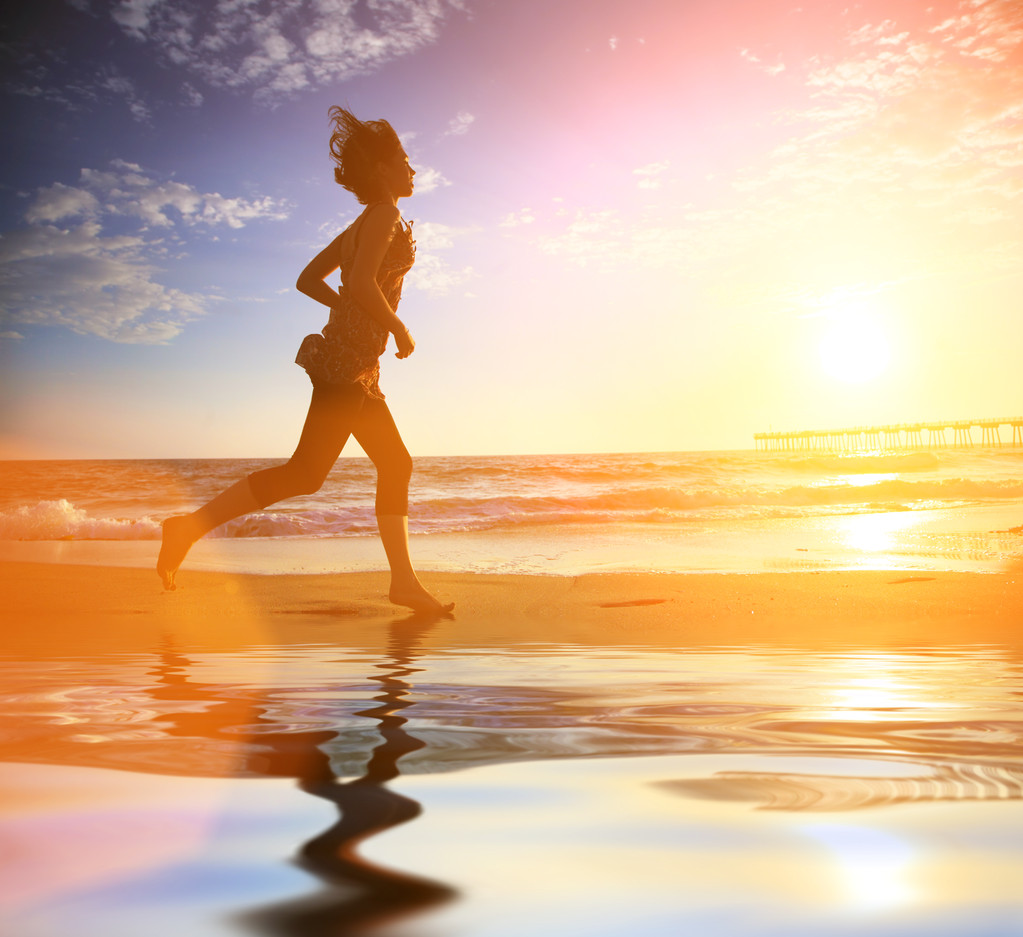 Mulher correndo pelo oceano ao pôr-do-sol
 - Foto, Imagem