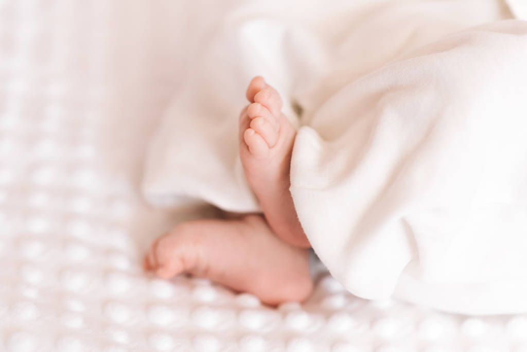 Lähikuva pieni suloinen paljas vaaleanpunainen vauvan jalat kuin vauvan hiha
 - Valokuva, kuva