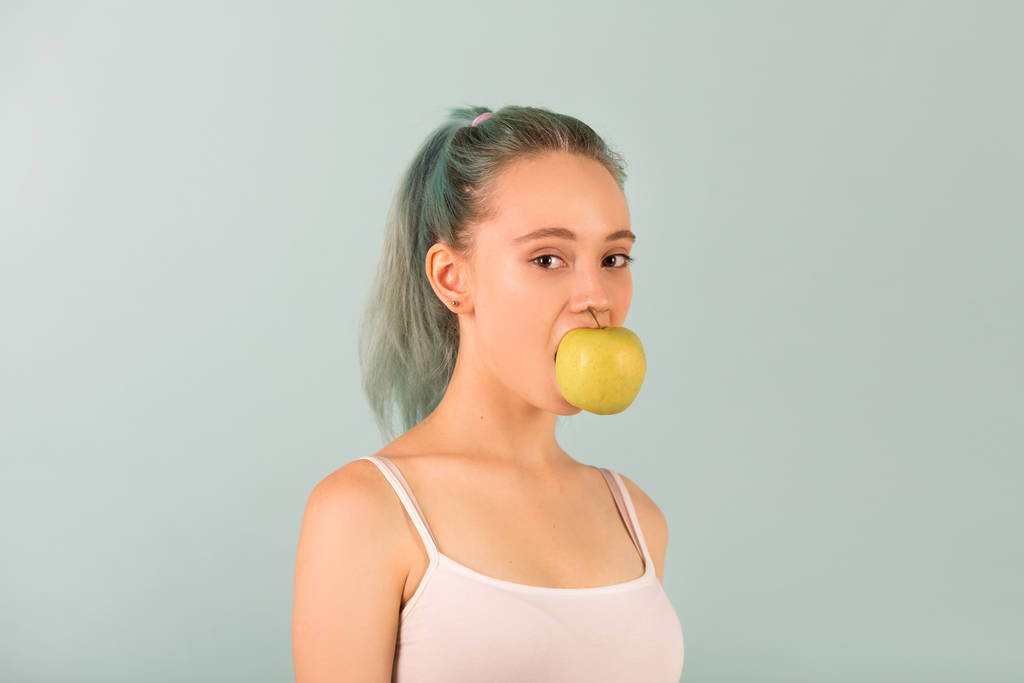 schöne schlanke junge Frau in Sportbekleidung mit einem Apfel in der Hand - Foto, Bild