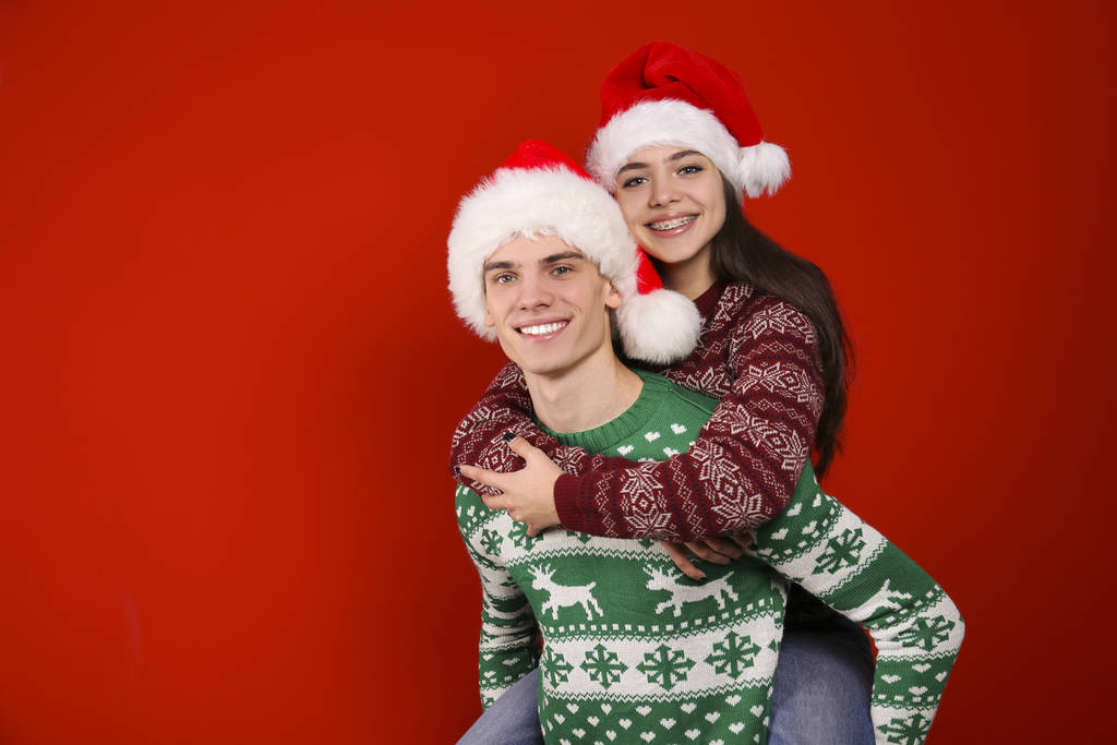 Пара молодих людей, одягнені в потворні різдвяні светри, позують на барвистому ізольованому фоні
. - Фото, зображення