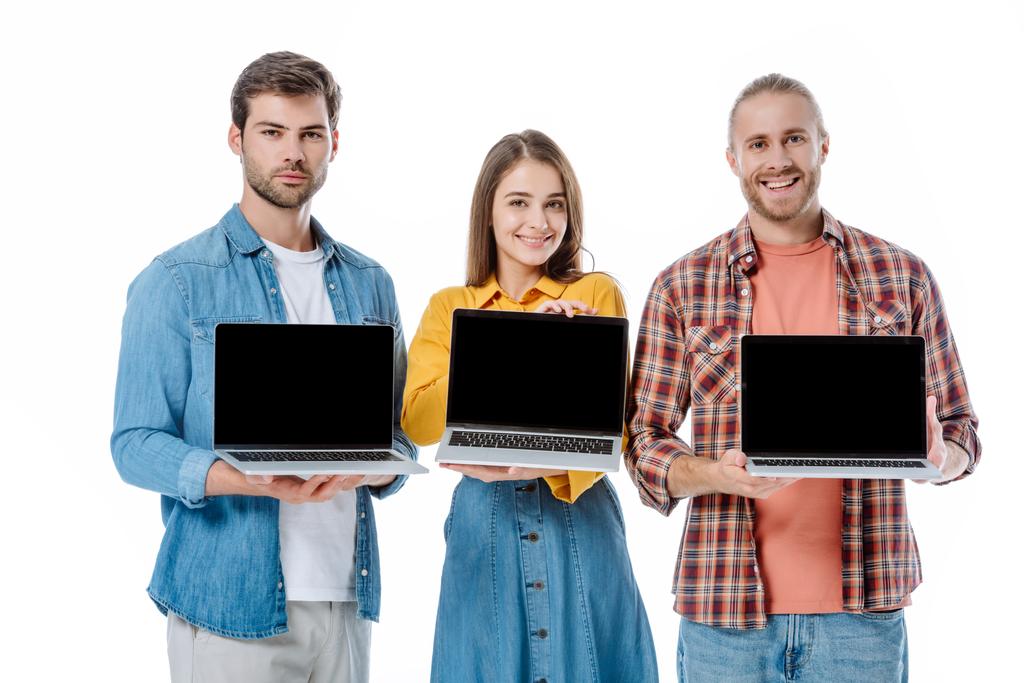glückliche junge Freunde halten Laptops mit leeren Bildschirmen isoliert auf weiß - Foto, Bild