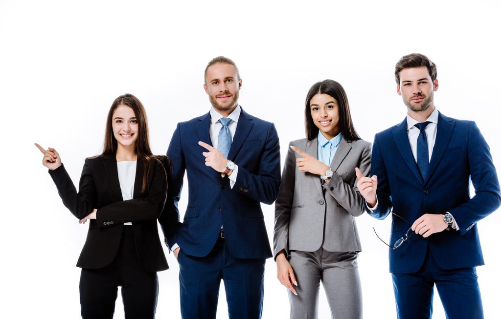 sonriente gente de negocios multicultural en trajes señalando con los dedos a un lado aislado en blanco
 - Foto, imagen