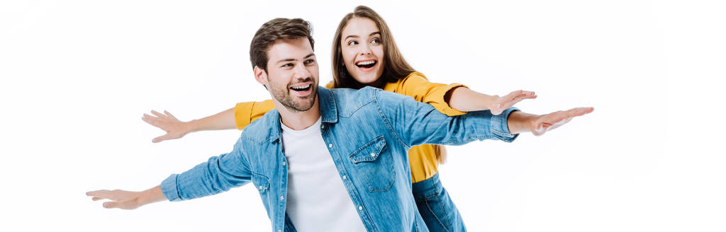 glückliches junges Paar in Jeans mit offenen Armen isoliert auf weißer, panoramischer Aufnahme - Foto, Bild