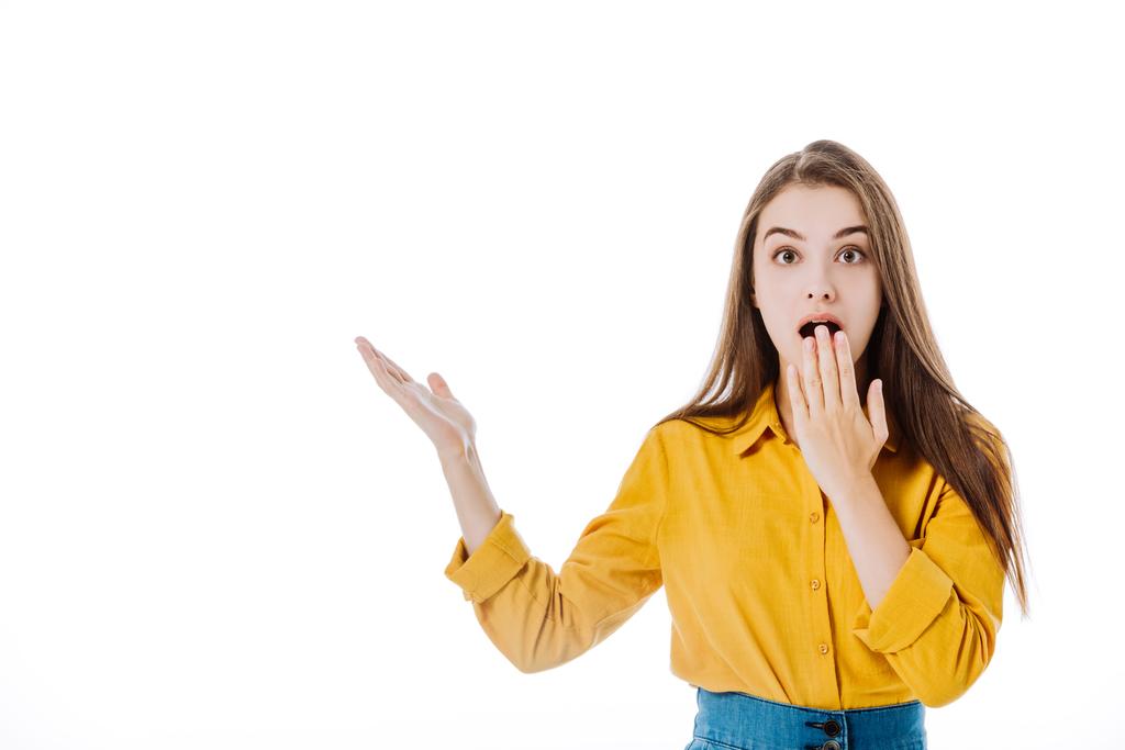потрясенный привлекательный девушка с открытым ртом указывая с рукой изолированы на белом
 - Фото, изображение