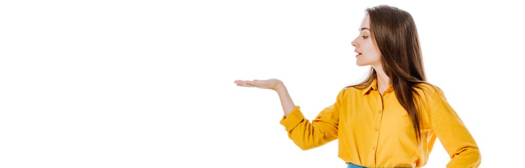 menina atraente apontando com a mão de lado isolado em branco, tiro panorâmico
 - Foto, Imagem