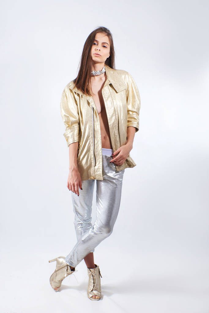 Mladá krásná dívka ve zlaté bundě a stříbrné kalhoty ve studiu - Fotografie, Obrázek