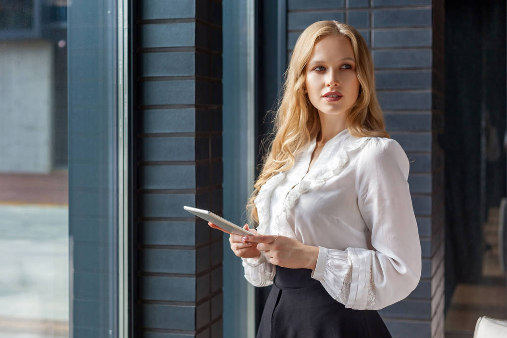 Portrait of attractive businesswoman looking aside and holding t - Photo, Image