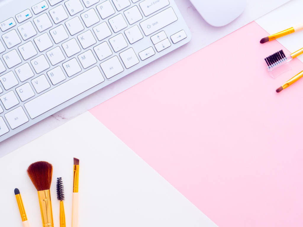 Beauty blogger Workplace. Pennelli e strumenti per il trucco, tastiera, mouse isolato su sfondo rosa con fogli bianchi su di esso. Posa piatta, spazio di copia
 - Foto, immagini
