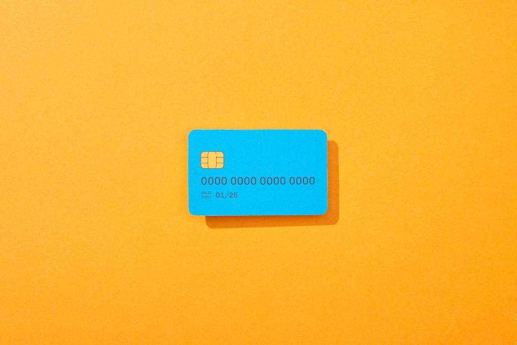 horní pohled na modrou šablonu kreditní karty na oranžovém pozadí - Fotografie, Obrázek