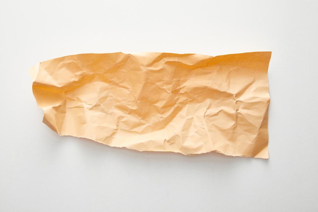 felső nézet üres narancs gyűrött papír fehér háttér - Fotó, kép