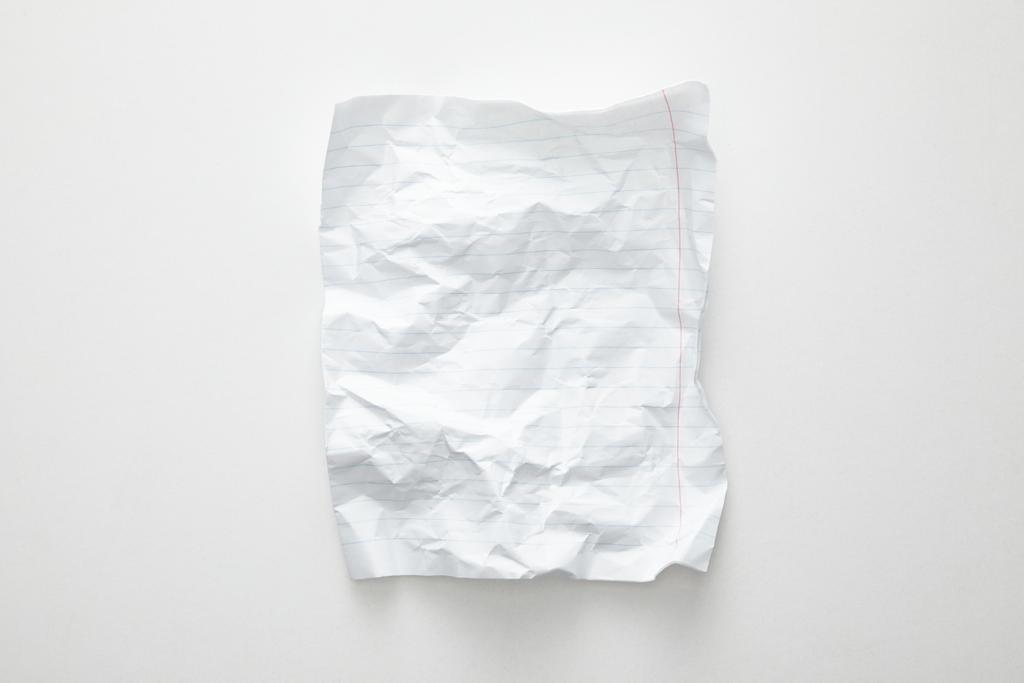 Draufsicht auf leeres zerknülltes Papier auf weißem Hintergrund - Foto, Bild
