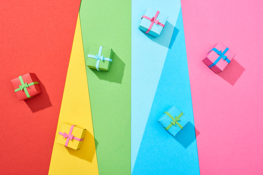 top view of multicolored gift boxes scattered on rainbow background - Photo, Image