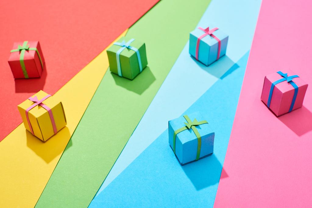 multicolored gift boxes scattered on rainbow background - Photo, Image