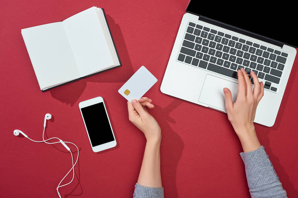 vue du dessus de la carte de crédit sur fond rouge avec smartphone, ordinateur portable, écouteurs, café, ordinateur portable et plante
 - Photo, image