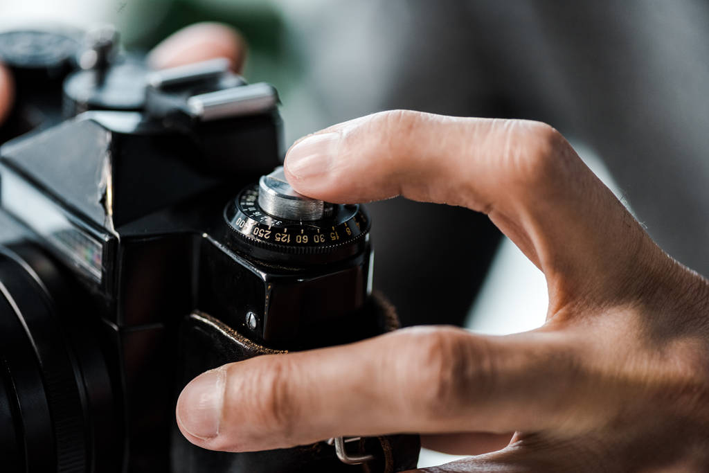 kivágott kilátás kétfajú férfi kezében digitális fényképezőgép a lakásban  - Fotó, kép