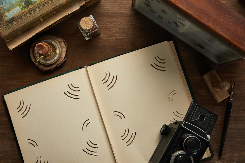 vista superior da câmera vintage, álbum de fotos, pintura, caneta-tinteiro, carimbo e relógio na mesa de madeira
 - Foto, Imagem