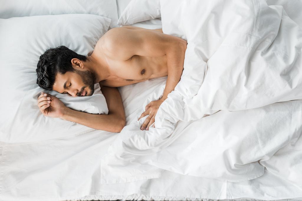 vista superior de sexy e bonito bi-racial homem dormindo na cama de manhã
  - Foto, Imagem