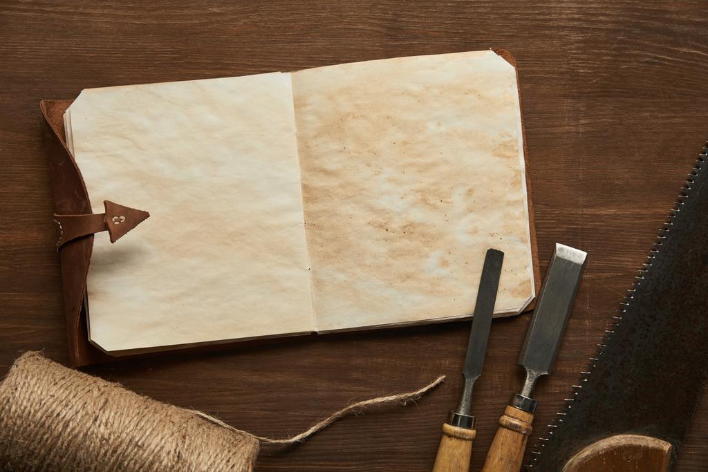 vista superior de ferramentas de carpintaria envelhecidas perto do caderno vintage em branco na mesa de madeira
 - Foto, Imagem