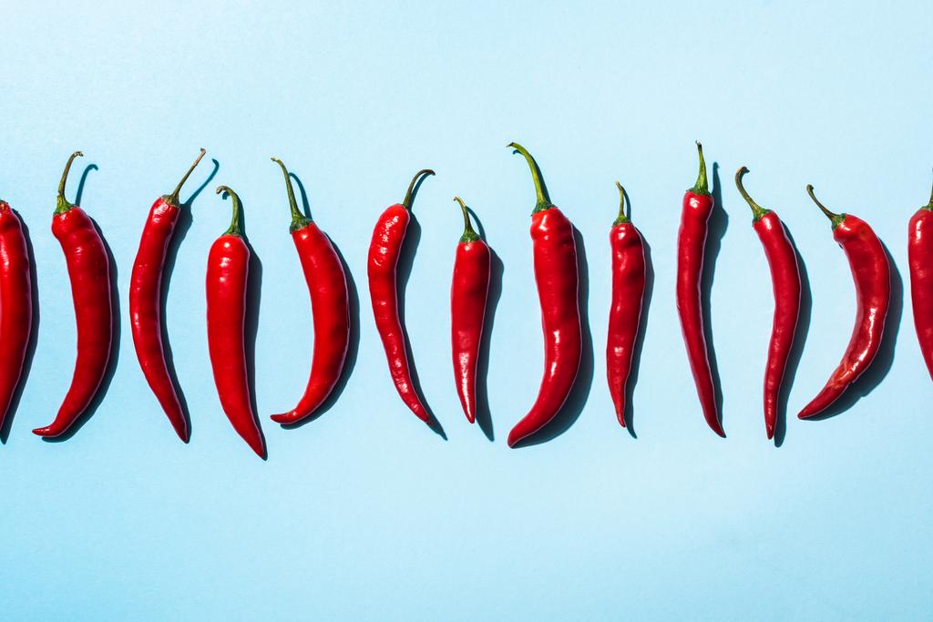Top view of spicy chili peppers on blue background - Photo, Image
