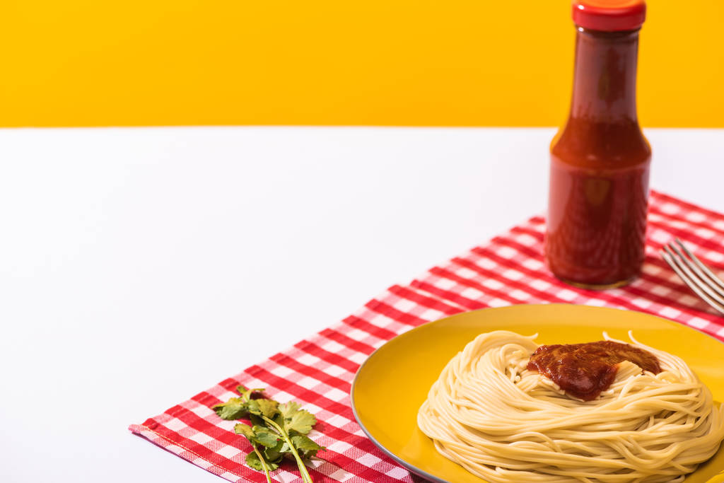 Spaghetti mit Tomatensauce neben Koriander auf weißer Oberfläche auf gelbem Hintergrund - Foto, Bild