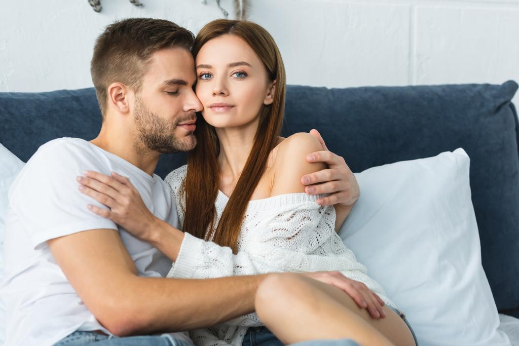 knappe man met gesloten ogen knuffelen aantrekkelijke vrouw in trui  - Foto, afbeelding