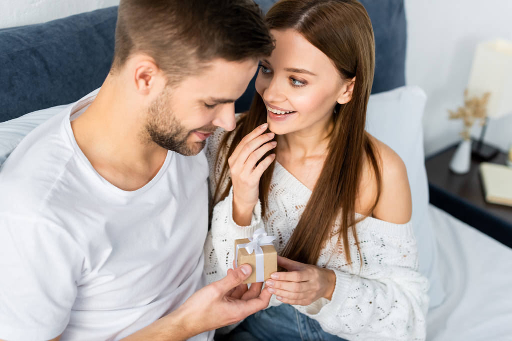 high angle view of smiling woman and handsome man holding gift box  - Photo, Image