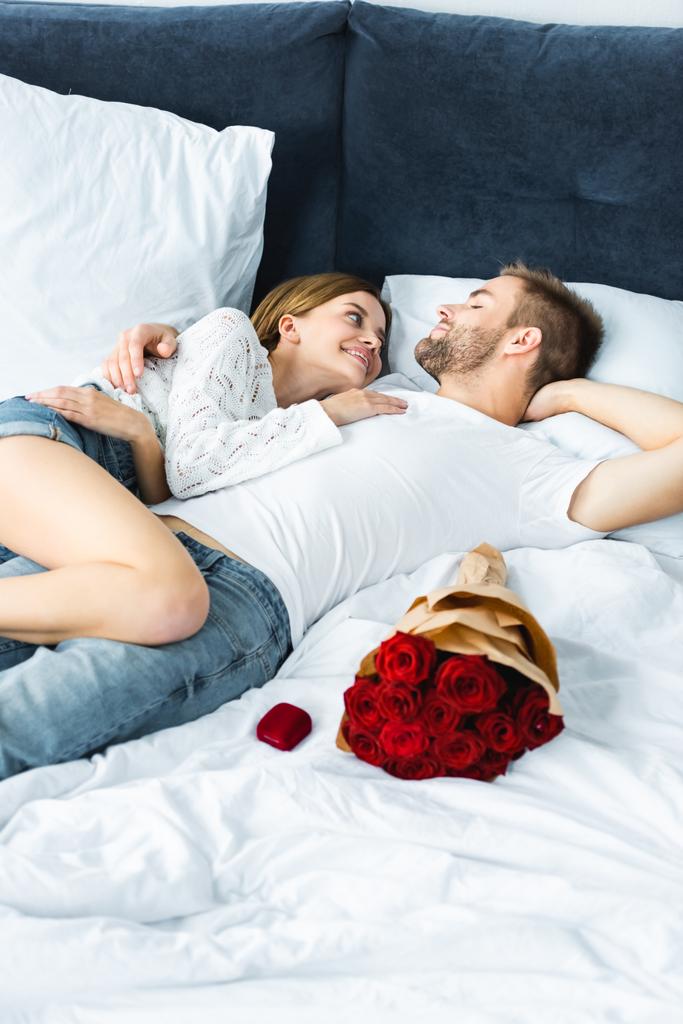Улыбающаяся и привлекательная женщина и красивый мужчина, обнимающийся в постели
  - Фото, изображение