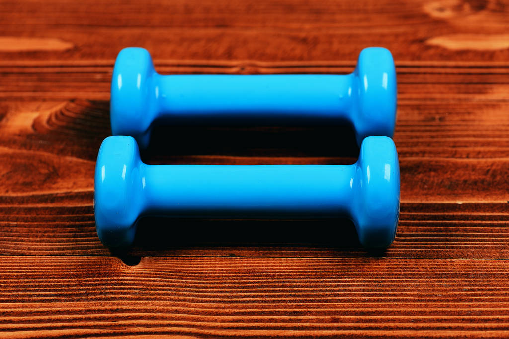 training concept, blue dumbbells on brown vintage wooden - Photo, Image