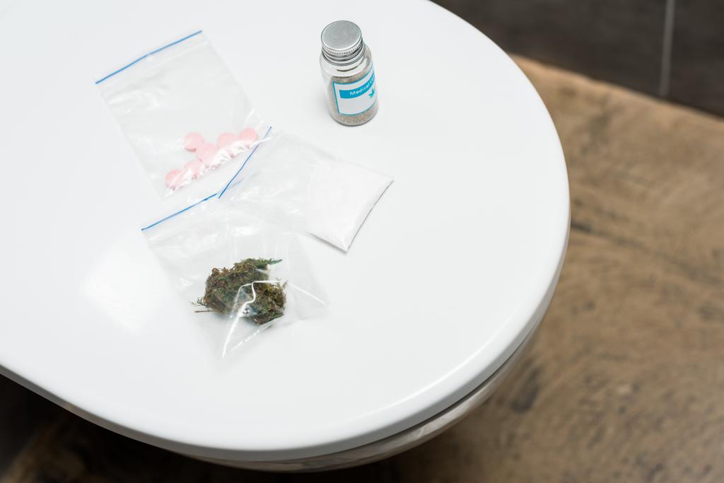 lsd, cogollos de marihuana, cocaína y cannabis medicinal en el inodoro
 - Foto, imagen