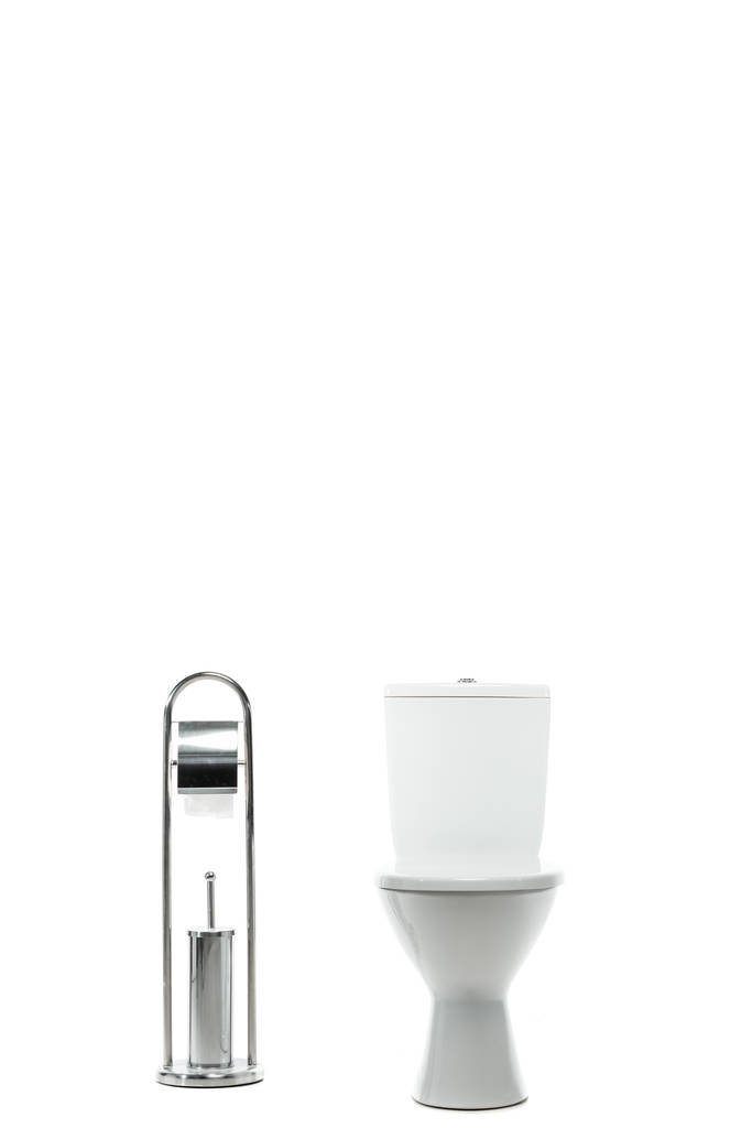 Keramik saubere Toilettenschüssel in der Nähe von Metallständer mit Toilettenpapier und Bürste isoliert auf weiß - Foto, Bild